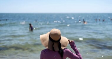 Ruth Wilson, who has lupus and is sensitive to the sun, stands at the water