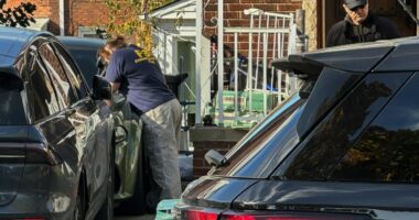 FBI agents gather outside a home in a Dearborn, Mich., neighborhood on Friday, Oct. 31, 2025. (AP Photo/Mike Householder)