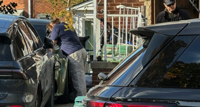 FBI agents gather outside a home in a Dearborn, Mich., neighborhood on Friday, Oct. 31, 2025. (AP Photo/Mike Householder)