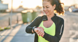 Middle age hispanic woman working out with smart watch outdoors