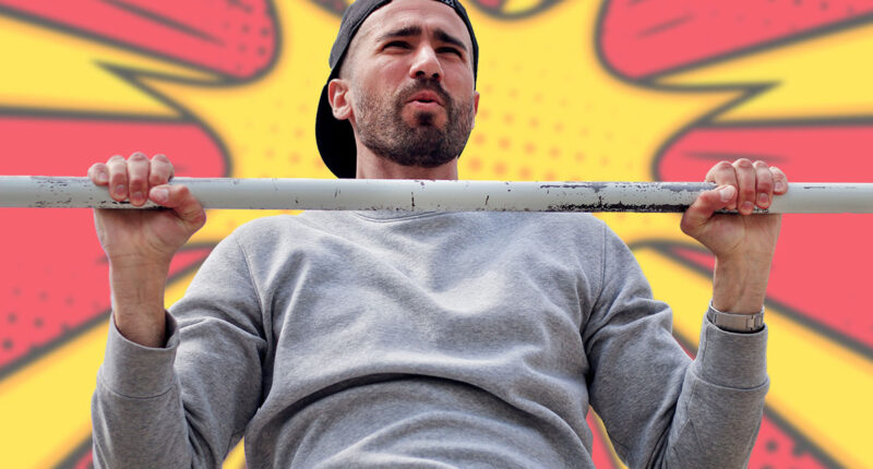 strong young man making exercises on the horizontal bar outdoor