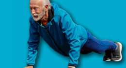 Full length of senior sportsman doing pushups on stadium.