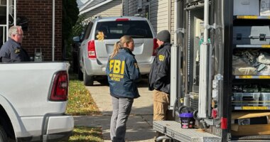 FBI agents gather outside a home in a Dearborn, Mich., neighborhood on Friday, Oct. 31, 2025. (AP Photo/Mike Householder)
