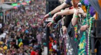FILE - Revelers throw beads from the balcony of the Royal Sonesta Hotel onto crowds on Bourbon Street during Mardi Gras festivities in the French Quarter in New Orleans, March 8, 2011. (AP Photo/Gerald Herbert, File)