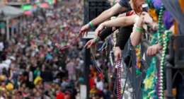 FILE - Revelers throw beads from the balcony of the Royal Sonesta Hotel onto crowds on Bourbon Street during Mardi Gras festivities in the French Quarter in New Orleans, March 8, 2011. (AP Photo/Gerald Herbert, File)