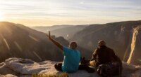 FILE - Visitors watch a sunset on rock ledge near Taft Point in Yosemite National Park, Calif., Oct. 30, 2025. (Stephen Lam/San Francisco Chronicle via AP, File)