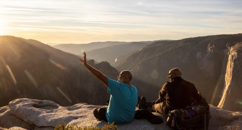 FILE - Visitors watch a sunset on rock ledge near Taft Point in Yosemite National Park, Calif., Oct. 30, 2025. (Stephen Lam/San Francisco Chronicle via AP, File)