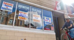 FILE - A bicyclist passes Definitive Selection clothing store, one of many businesses in the predominantly Latino neighborhood that has seen a slowdown in foot traffic since President Donald Trump