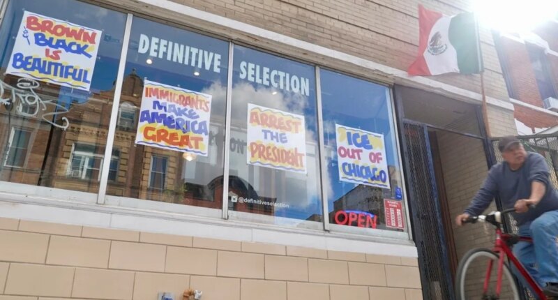 FILE - A bicyclist passes Definitive Selection clothing store, one of many businesses in the predominantly Latino neighborhood that has seen a slowdown in foot traffic since President Donald Trump