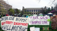 FILE - Signs are displayed outside a tent encampment at Northwestern University on April 26, 2024, in Evanston, Illinois. (AP Photo/Teresa Crawford, file)