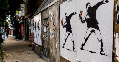 FILE - Posters of a person throwing a sandwich are pictured along H Street, Aug. 17, 2025, in Washington. (AP Photo/Julia Demaree Nikhinson, File)
