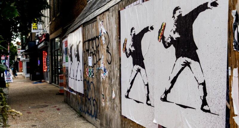 FILE - Posters of a person throwing a sandwich are pictured along H Street, Aug. 17, 2025, in Washington. (AP Photo/Julia Demaree Nikhinson, File)