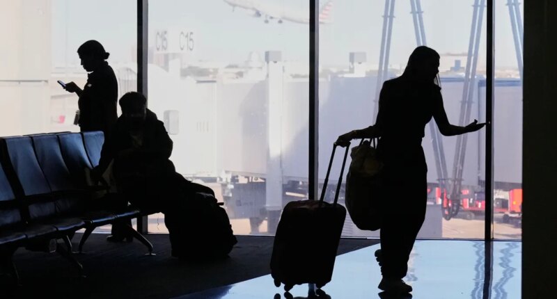 Travelers wait at a gate for their departing flight at the Dallas Fort Worth International Airport, at DFW Airport, Texas, Friday, Nov. 21, 2025. (AP Photo/Tony Gutierrez)