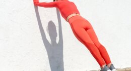 Sporty woman doing push off exercises against a wall