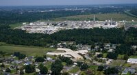 FILE - The Fifth Ward Elementary School and residential neighborhoods sit near the Denka Performance Elastomer Plant, back, in Reserve, La., Sept. 23, 2022. (AP Photo/Gerald Herbert, File)