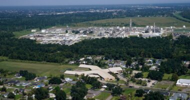 FILE - The Fifth Ward Elementary School and residential neighborhoods sit near the Denka Performance Elastomer Plant, back, in Reserve, La., Sept. 23, 2022. (AP Photo/Gerald Herbert, File)