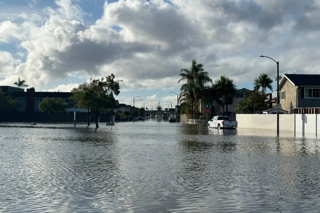 A local pond overflows into a residential neighborhood in Huntington Beach, Calif. following a storm on Friday, Nov. 21, 2025. (AP Photo/Amy Taxin)