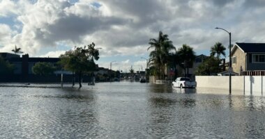A local pond overflows into a residential neighborhood in Huntington Beach, Calif. following a storm on Friday, Nov. 21, 2025. (AP Photo/Amy Taxin)