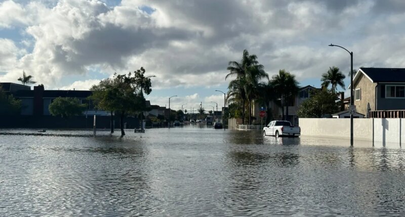A local pond overflows into a residential neighborhood in Huntington Beach, Calif. following a storm on Friday, Nov. 21, 2025. (AP Photo/Amy Taxin)