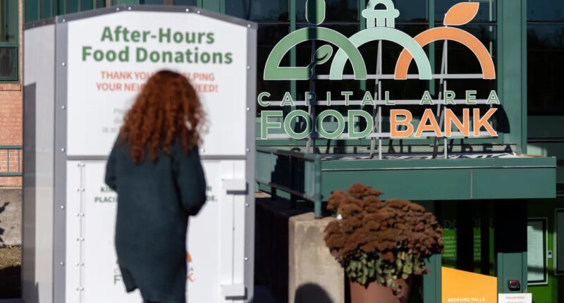 A person walks toward the entrance of the Capital Area Food Bank, Thursday, Nov. 6, 2025, in Washington. (AP Photo/Mark Schiefelbein)