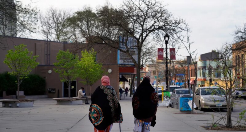 FILE - Women walk down a street in the predominantly Somali neighborhood of Cedar-Riverside in Minneapolis on May 12, 2022. (AP Photo/Jessie Wardarski, File)