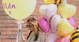 A woman carries balloons to the funeral of Bondi Beach mass shooting victim 10-year-old Matilda, whose last name is being withheld at the request of her family, in Sydney, Thursday, Dec. 18, 2025. (AP Photo/Steve Markham)