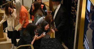 Relatives of Rabbi Eli Schlanger, who was killed in the Bondi Beach terror attack, draped over his coffin during his funeral at Chabad of Bondi.