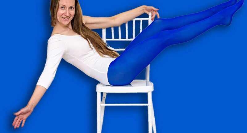 I love yoga. Portrait of a beautiful woman on a white background doing exercises on a chair.