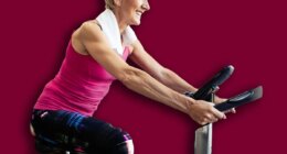 Happy fit mature woman and man cycling on exercise bikes to stay healthy