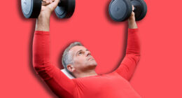Mature man lifting dumbells at fitness gym