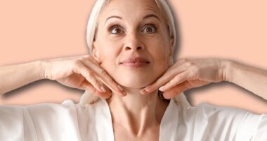 Mature woman doing face building exercise on light background