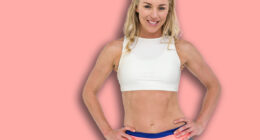 Portrait of athlete standing with hand on hip on white background