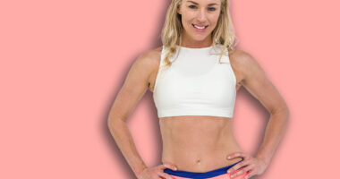 Portrait of athlete standing with hand on hip on white background