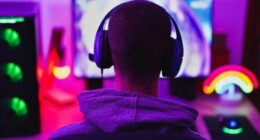 Young man wearing headset and play computer video games online - Home isolated for coronavirus outbreak