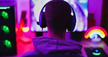 Young man wearing headset and play computer video games online - Home isolated for coronavirus outbreak