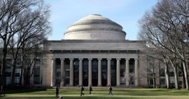 FILE - Students walk past the