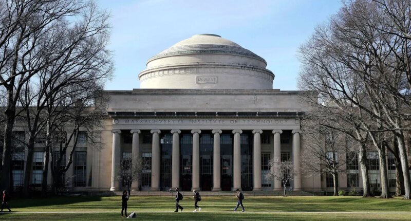 FILE - Students walk past the