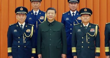 Chinese President Xi Jinping, also chairman of the Central Military Commission (CMC), front row second from left, poses with other military officers after promoting to generals, back row, from left, Yang Zhibin of the Eastern Theater Command and Han Shengyan commander of Central Theater Command in Beijing on Monday, Dec. 22, 2025. (Li Gang/Xinhua via AP)