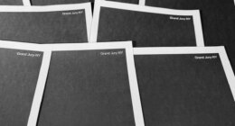 Pages from a totally redacted New York grand jury file into Jeffrey Epstein and Ghislaine Maxwell, released by the U.S. Justice Department, is photographed Friday, Dec. 19, 2025, in Washington. (AP Photo/Jon Elswick)