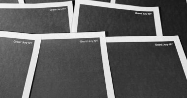 Pages from a totally redacted New York grand jury file into Jeffrey Epstein and Ghislaine Maxwell, released by the U.S. Justice Department, is photographed Friday, Dec. 19, 2025, in Washington. (AP Photo/Jon Elswick)