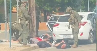 Multiple men were seen in handcuffs.