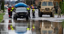 Emergency crews, including National Guard soldiers, wort in a neighborhood flooded by the Skagit River on Friday, Dec. 12, 2025, in Burlington, Wash. (AP Photo/Stephen Brashear)