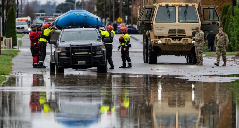 Emergency crews, including National Guard soldiers, wort in a neighborhood flooded by the Skagit River on Friday, Dec. 12, 2025, in Burlington, Wash. (AP Photo/Stephen Brashear)
