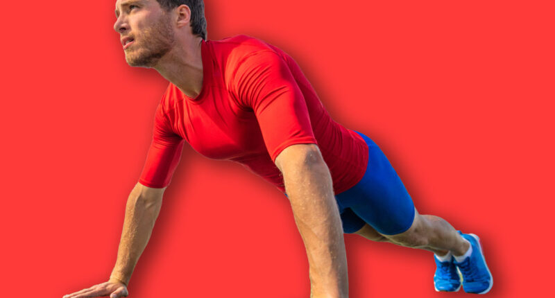 Fit man doing push ups exercise at outdoor gym. Core body workout athlete planking or doing pushup on grass.