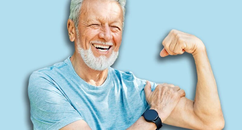 Portrait of a happy positive old senior man showing biceps and power standing outdoors in park or nature, healthy lifestyle, active senior, vitality and humor concepts