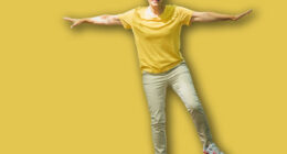 Balancing exercise outdoors. Mature woman standing on one leg, exercising balance