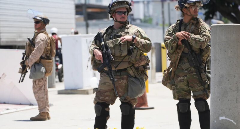 FILE - Members of the California National Guard and U.S. Marines guard a federal building on Tuesday, June 17, 2025, in Los Angeles. (AP Photo/Damian Dovarganes, File)