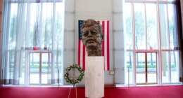 FILE - A memorial wreath stands next to the bronze memorial bust by Robert Berks of President John F. Kennedy in the grand foyer at the John F. Kennedy Center for the Performing Arts in Washington, Nov. 22, 2013, on the 50th anniversary of Kennedy