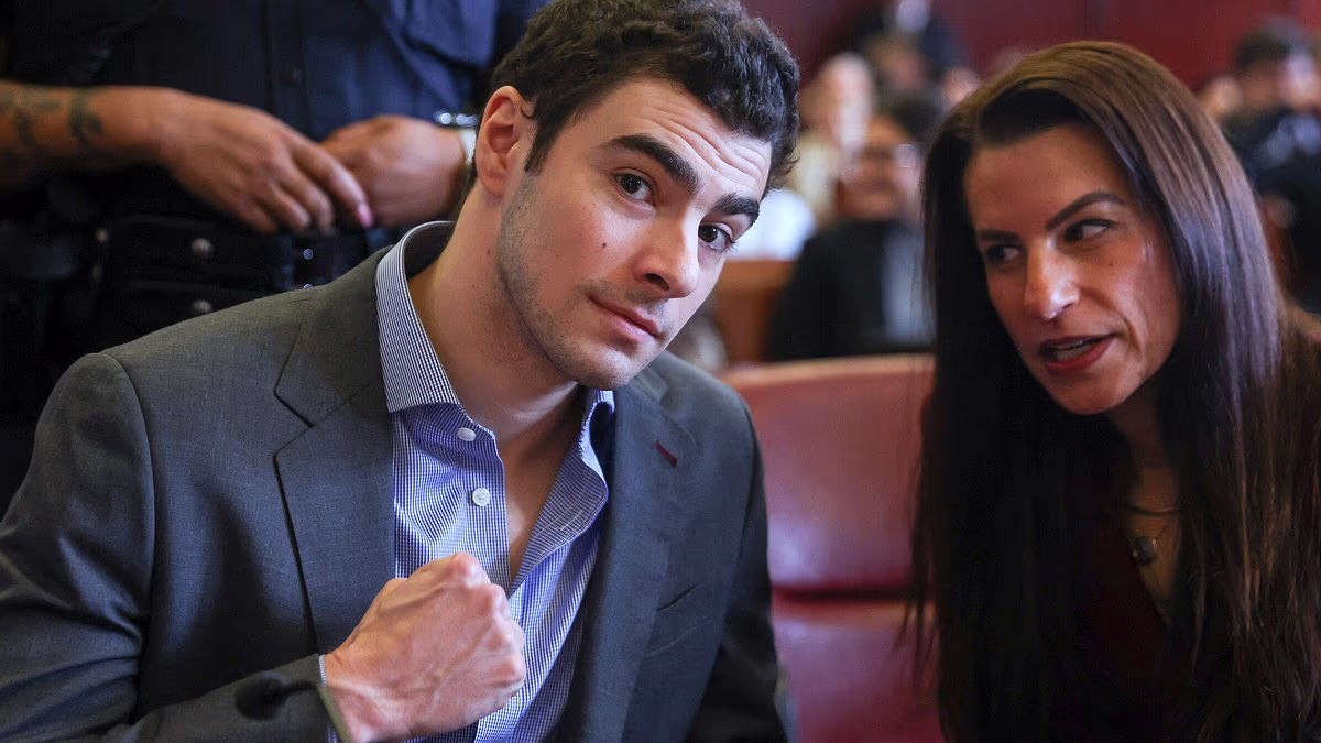 Luigi Mangione pumps his fist as he gleams during court hearing