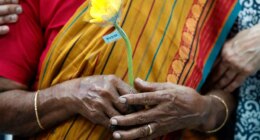 FILE - A family member of passengers on board of the missing Malaysia Airlines Flight 370 holds a flower during the tenth annual remembrance event at a shopping mall, in Subang Jaya, on the outskirts of Kuala Lumpur, Malaysia, March 3, 2024. (AP Photo/FL Wong, File)